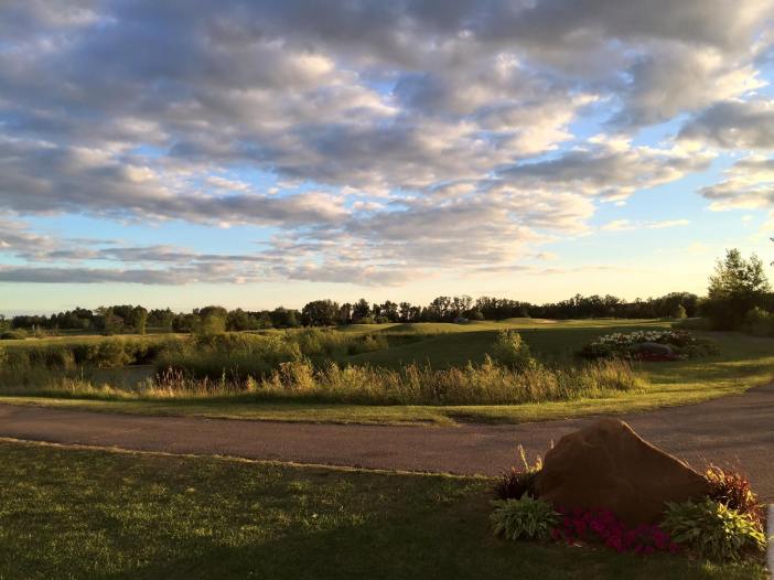 View of golf course under cloudy skies at twilight