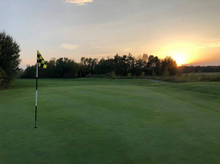 Golf course green with flag over hole